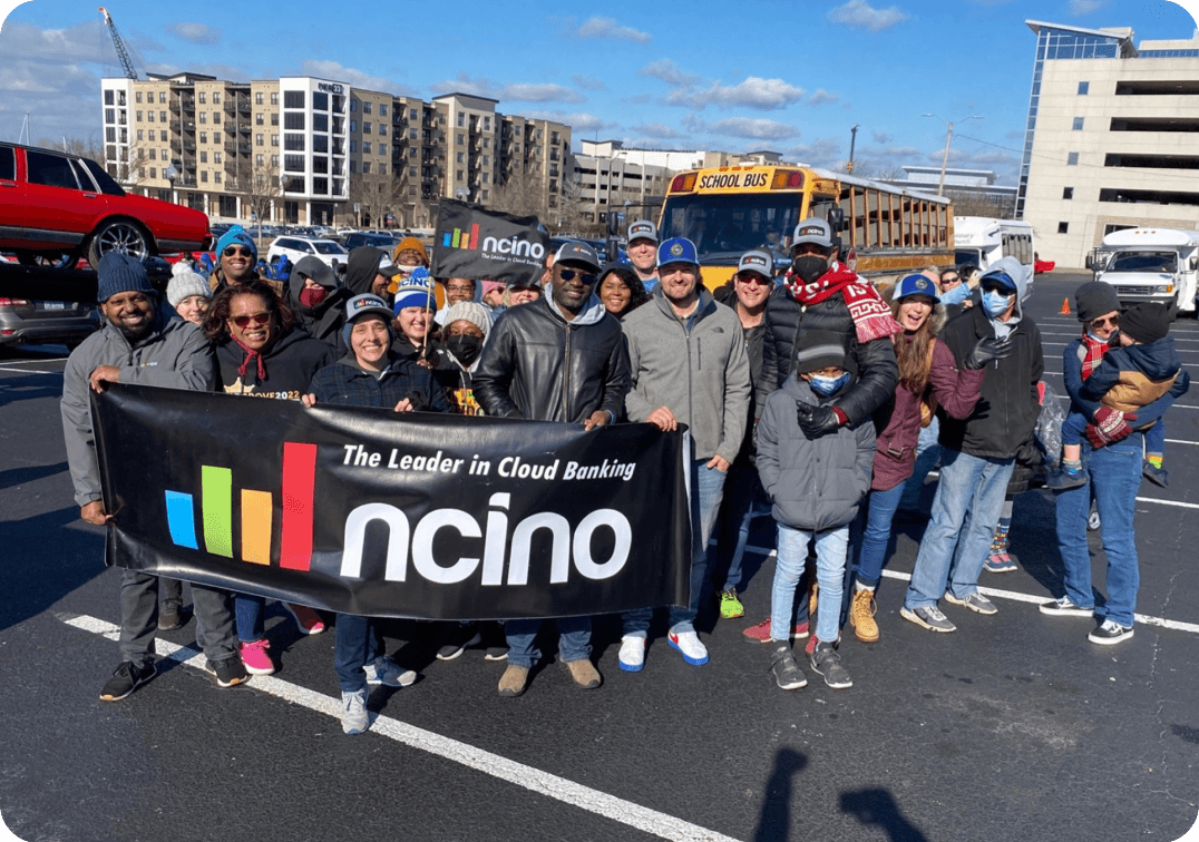 Employees hold a nCino banner at a local Martin Luther King Junior Day parade in the cold.